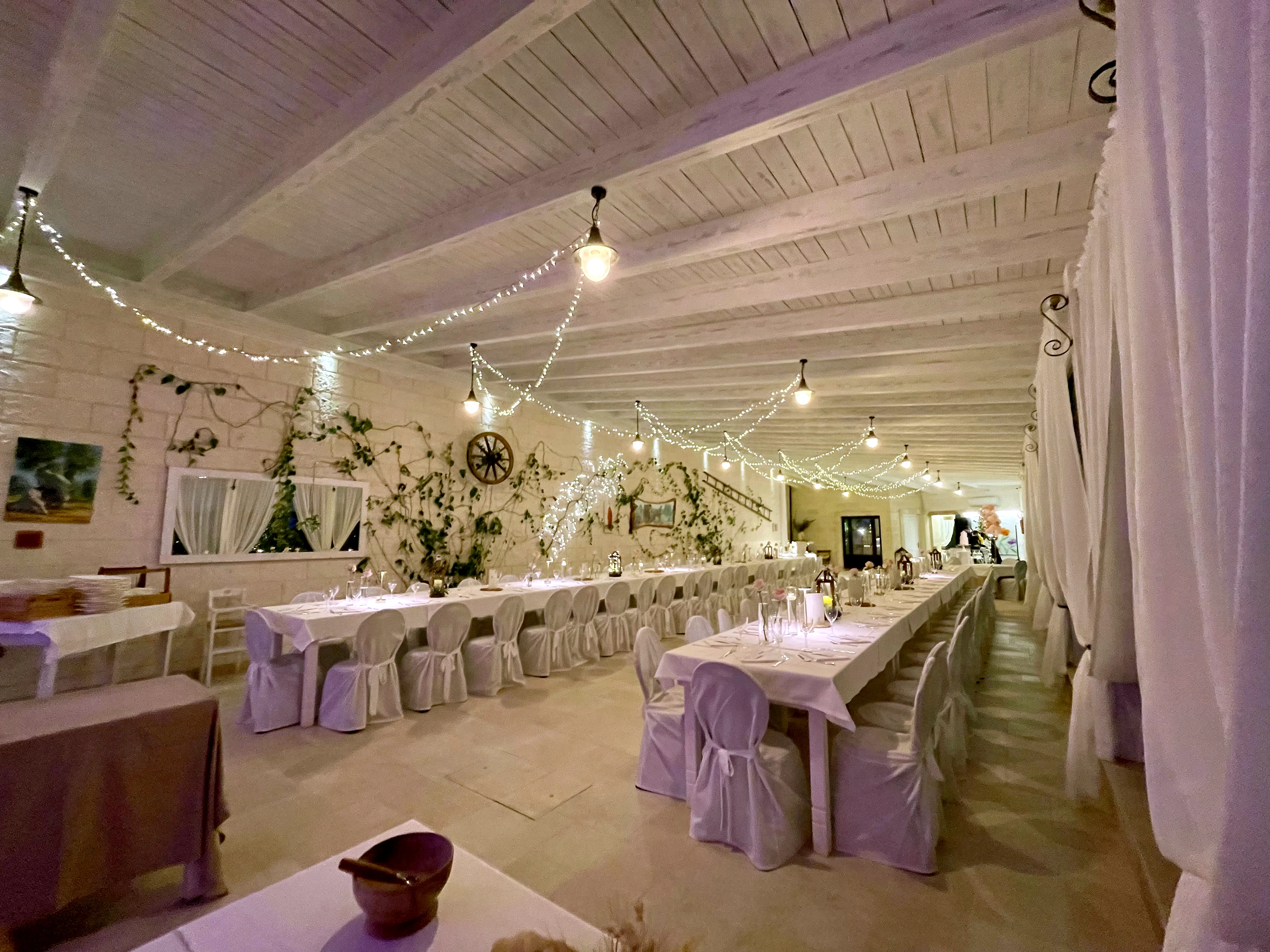 La sala interna della Masseria allestita per un ricevimento, tra tavoli e luci calde