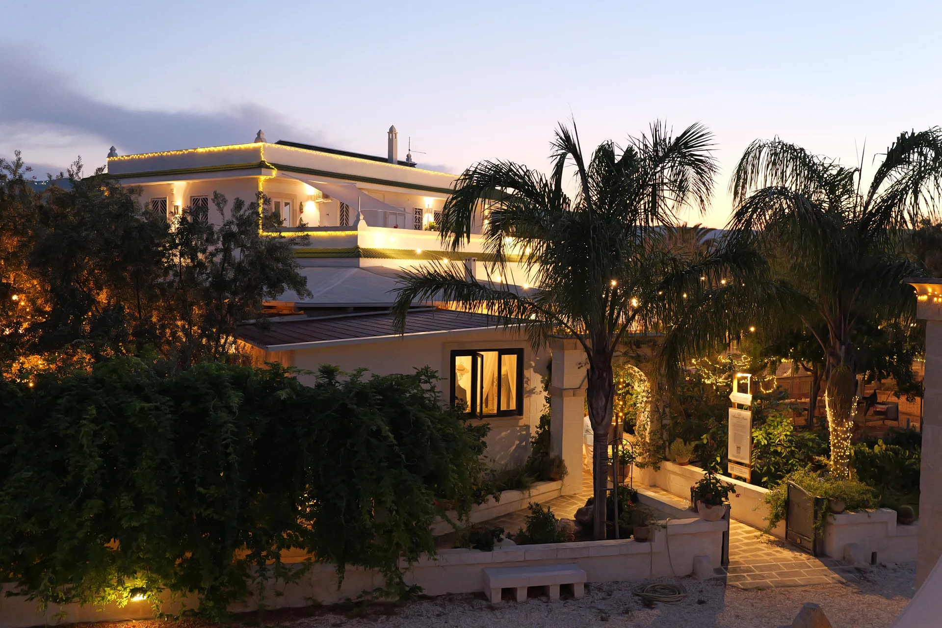 La Masseria al tramonto, tra palme e giardini illuminati